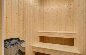 eine Holzsauna mit einer Bank und einem WC in der Unterkunft Gorgeous Home In Grenaa With Sauna in Brøndstrup + 28 Fotos