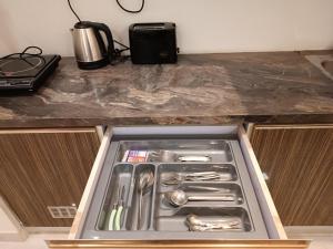 a drawer in a kitchen with utensils in it at North Eye Studio in Noida