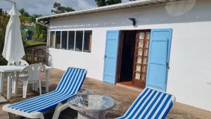 La MontagneStudio cosy avec terrasse à La Montagne 25 m²的庭院设有两把椅子和一张桌子,还有一间房子