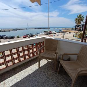 a bar with two chairs and a view of the beach at Peristerianos apartments in Nea Skioni