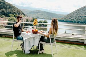 a man and woman sitting at a table on a balcony at Hotel Del Lago 1934 & SPA in Piediluco