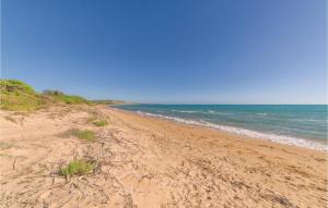 una playa de arena con el océano al fondo en Stunning Home In Menfi Ag With Kitchen, en Portopalo di Capo Passero