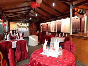 a party hall with red clothed tables and red chairs at Hôtel du Boulevard in Brazzaville