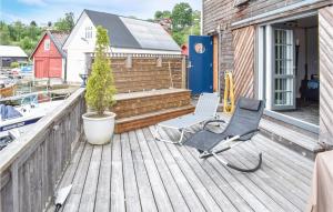 a chair on a deck with a potted tree at Gorgeous Home In Os With Kitchen in Haljem