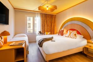 a hotel room with two beds and a desk at Nice Pam Hotel in Nice