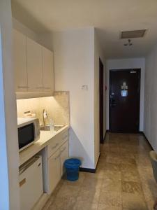 a kitchen with a sink and a microwave at Standard Times Square Suite Kuala Lumpur in Kuala Lumpur +30 photos