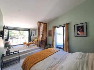 a bedroom with a large bed and a large window at La Pinède de Venelles Jacuzzi privatif in Venelles