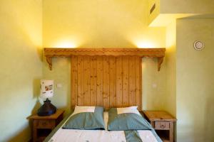 a bedroom with a bed with a wooden headboard at Le Calmadou in Formiguères