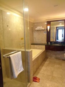 a bathroom with a shower and a tub and a sink at Standard Times Square Suite Kuala Lumpur in Kuala Lumpur
