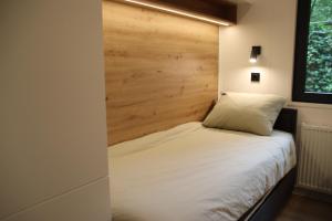 a bedroom with a bed with a wooden headboard at Boshuis Dreamstay Gorssel in Gorssel