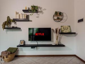 Una sala de estar con un televisor en una pared blanca. en Ivy's Home, en Rávena 19 fotos más