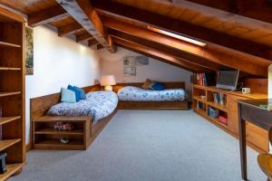 two beds in a room with wooden ceilings at Al Mulino - immerso nel Golf Resort in Polpenazze del Garda +18 photos
