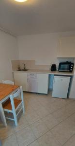 a kitchen with a counter and a table and a microwave at Flat Panorama Sea View Studio for Couples Vrachos in Preveza +23 photos