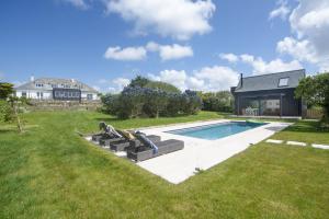a backyard with a swimming pool and a house at Westaway House in Port Isaac