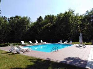 a swimming pool with lounge chairs and a bunch at Al Mulino - immerso nel Golf Resort in Polpenazze del Garda