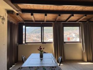 a dining room with a table and two windows at Suite de la Sicilienne in Castellammare del Golfo