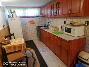 a kitchen with wooden cabinets and a white refrigerator at Chata u Jany domček in Ždiar