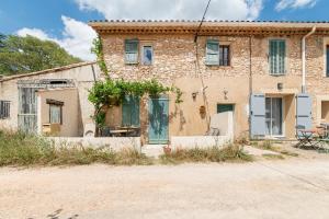 an old stone house with a table and chairs in front of it at Coeur de Var - appt climatisé in Pontevès