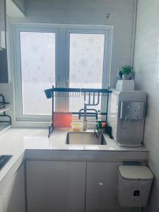 a kitchen with a sink and a window at La Villa in Kampong Ru Sepuloh