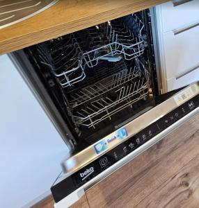 an open dishwasher with racks inside of it at Apartament Pasaż, 2 Sypialnie i Salon, Centrum in Giżycko