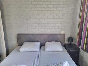 ユリアーナドルプにあるBungalow Noordzee Fのベッド1台(上に白い枕2つ付)