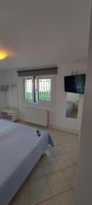 a bedroom with a bed and a flat screen tv at Flat Panorama Sea View Studio for Couples Vrachos in Preveza