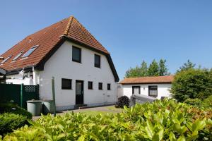 une maison blanche avec un toit marron dans l'établissement Gartenwohnung, à Westerdeichstrich