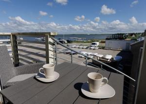two cups of coffee sitting on a table on a balcony at Grand Holm Marina Kipperi apartment in Haapsalu