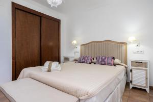 een slaapkamer met twee bedden met kussens erop bij Ático en los Albatros by Sit Isla Canela in Ayamonte +45 foto's