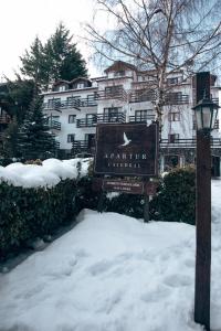 a sign in the snow in front of a building at Apartur Catedral in San Carlos de Bariloche