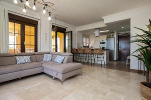 een woonkamer met een bank en een keuken bij Ático en los Albatros by Sit Isla Canela in Ayamonte