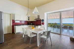 a kitchen with a table and chairs with a view of the ocean at Villa Miramare by Perle di Puglia in Torre Suda