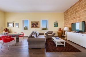 a living room with a couch and a tv at Villa Miramare by Perle di Puglia in Torre Suda