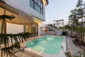 a pool with a slide in a building at Esther Villa Khaoyai in Ban Bung Toei