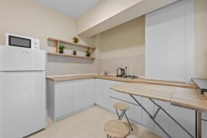 a kitchen with white cabinets and a wooden table at CORAL Studio in Eforie Nord