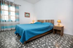 a bedroom with a bed with a blue blanket at PANORAMA in Potos