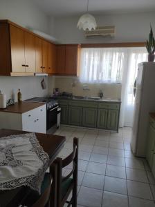 a kitchen with wooden cabinets and a table with a tableablish at Anastasia in Kyparissia