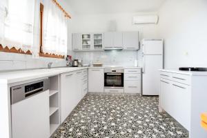 a kitchen with white appliances and a tile floor at PANORAMA in Potos