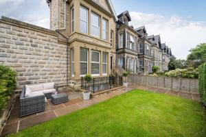 a house with a lawn in front of it at SixtyTwo by Harrogate Serviced Apartments in Harrogate