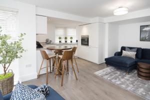 a living room with a table and a blue couch at SixtyTwo by Harrogate Serviced Apartments in Harrogate