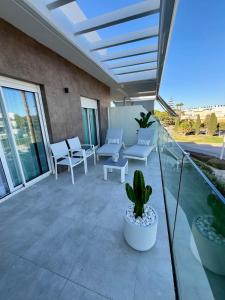 eine Terrasse mit weißen Stühlen und einem Kaktus in der Unterkunft Costa Ballena & Eleven Lights in Chipiona