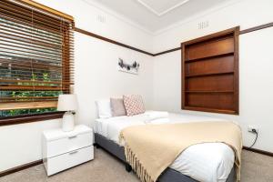 una camera da letto con un letto e una finestra di Beautifully Renovated Inner North Residence - Hosted by CanStay a Canberra