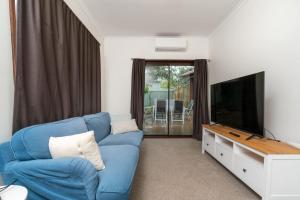 un soggiorno con un divano blu e una TV a schermo piatto di Beautifully Renovated Inner North Residence - Hosted by CanStay a Canberra