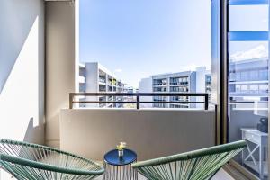 a balcony with two chairs and a table at Parliamentary Triangle 1BR Apartment - Hosted by CanStay in Canberra