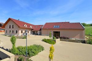 duży budynek z czerwonym dachem w obiekcie Penzion Harmonie w mieście Žlutice