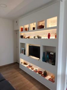 un soggiorno con scaffali bianchi e TV di Casa Ocre Alojamento Local ad Abrantes