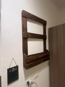 a wooden shelf hanging on a wall next to a refrigerator at L'Angolo Di San Pietro in Rome