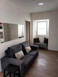 un soggiorno con divano nero e sedia di Casa Ocre Alojamento Local ad Abrantes