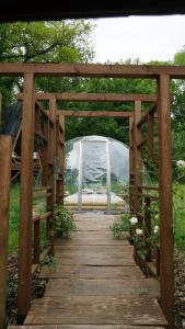a wooden bridge with a tent in a field at Ô Pays Des Bois - Hébergements insolites en pleine nature in Parmilieu