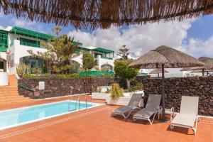 科斯塔特吉塞Golf y Mar A Suites的一个带椅子和遮阳伞的游泳池的度假酒店